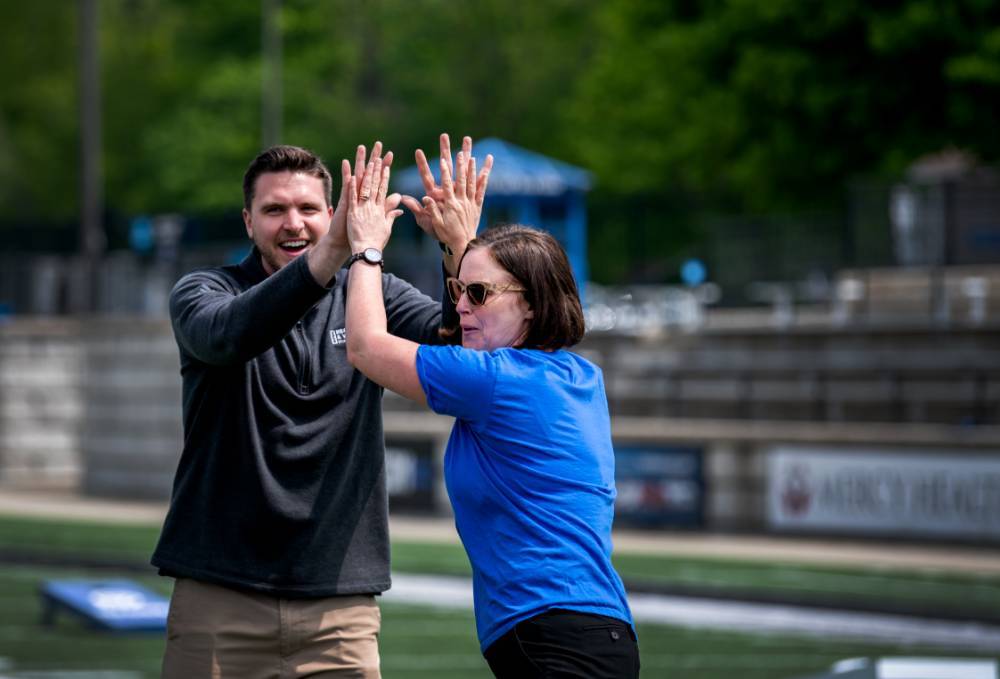 Jenny Hall-Jones and Mike Przyzdial high-fiving during the 2022 Cornhole Tournament